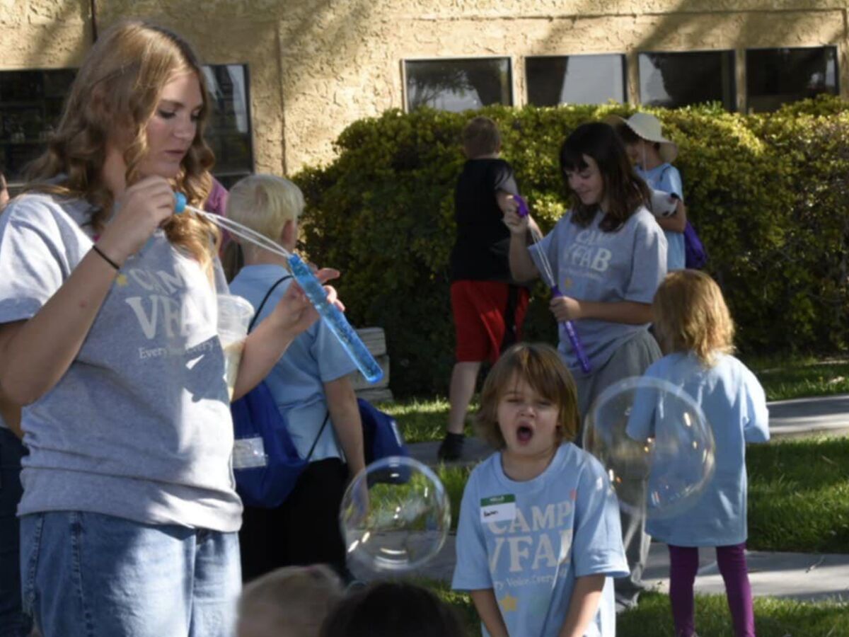 Children painting at an inclusive craft table