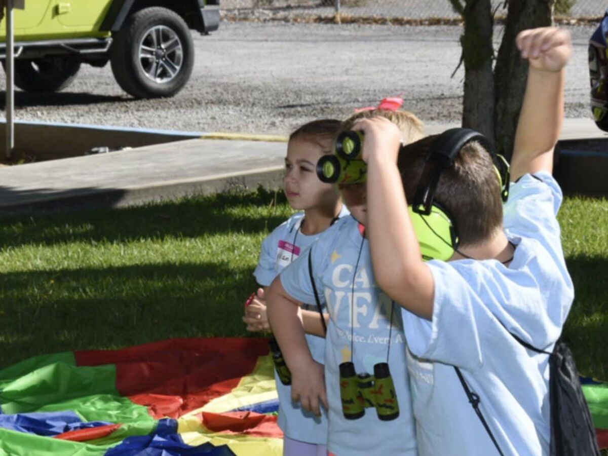 A camper and a buddy volunteer smiling during an activity